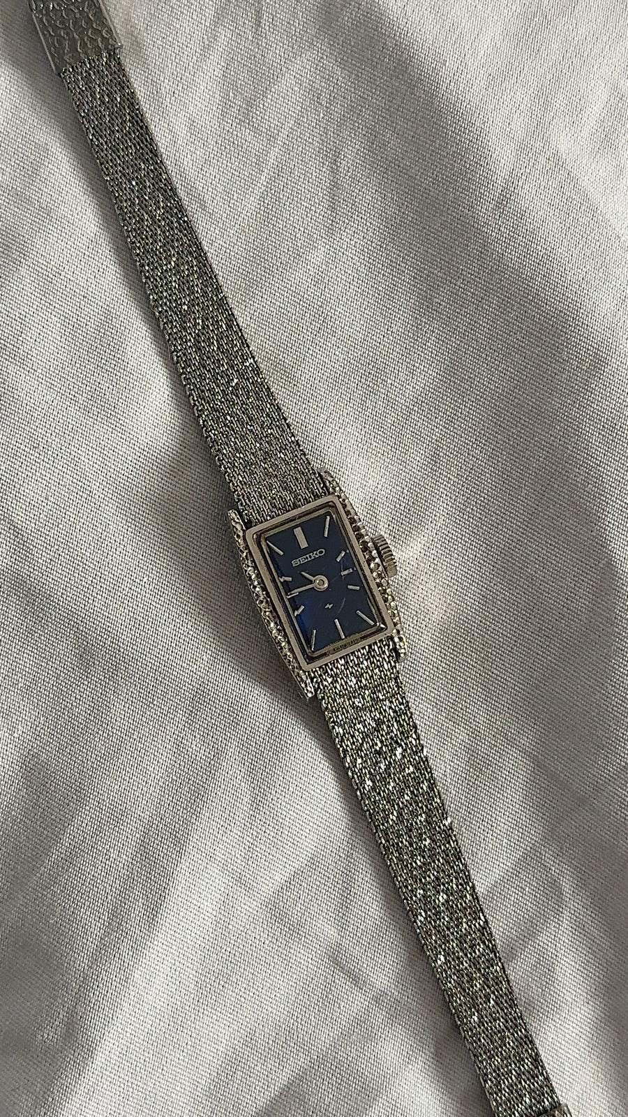 WORKING SILVER-TONE SEIKO CLASP WATCH WITH A BLUE DIAL